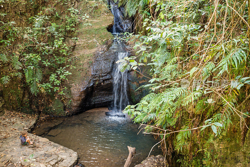 蹒跚学步的孩子坐着放松的瀑布Pirenópolis Goiás